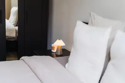 a bedroom with two beds and a lamp on a table at Elegant 3BR & 1LR Waterfront Retreat in Ghent in Ghent