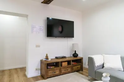 a living room with a couch and a tv on a wall at Elegant 3BR & 1LR Waterfront Retreat in Ghent in Ghent