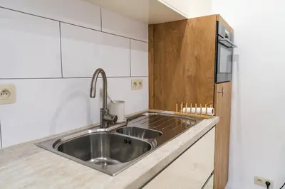 a kitchen with a stainless steel sink and a refrigerator at Elegant 3BR & 1LR Waterfront Retreat in Ghent in Ghent