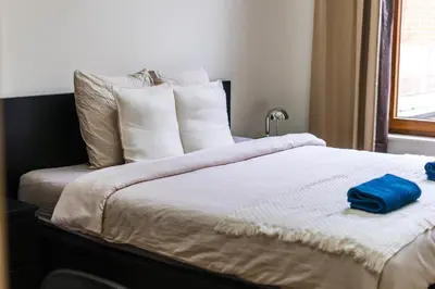 a bed with white pillows and a blue towel on it at Elegant 3BR & 1LR Waterfront Retreat in Ghent in Ghent
