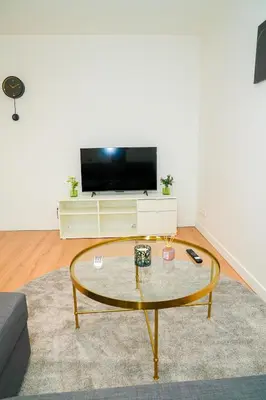 a living room with a tv and a coffee table at Modern 1BR & 1LR Apartment, 10 min Walk to City Center in Ghent