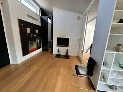 a living room with a fireplace and a chair at Villa 'L' in Brussels