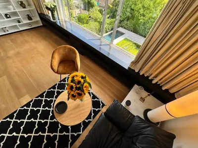 a living room with a table and a chair and a window at Villa 'L' in Brussels