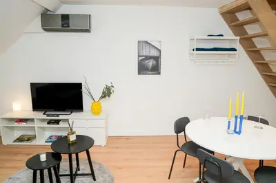 a living room with a table and chairs and a tv at Chic & Modern 1BR & 1LR Apt, 12 Min Walk to Rabot in Ghent