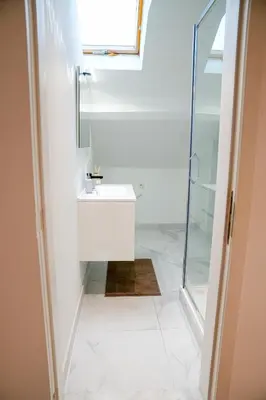 a white bathroom with a sink and a shower at Chic & Modern 1BR & 1LR Apt, 12 Min Walk to Rabot in Ghent