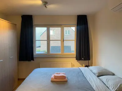 a bedroom with a large bed and a window at Casa Duffla in Duffel