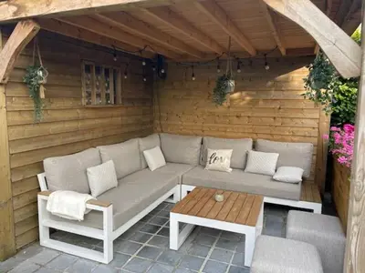 a patio with a couch and a table on a patio at Casa Duffla in Duffel