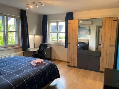 a bedroom with a blue bed and a large mirror at Casa Duffla in Duffel