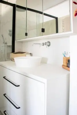 a white bathroom with a sink and a mirror at Cozy apartment - Super central in Brussels