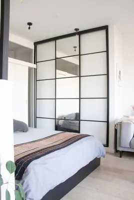 a bedroom with a large bed with glass doors at Cozy apartment - Super central in Brussels