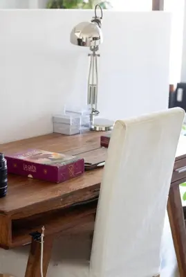 a table with a white chair and a desk with a lamp at Cozy apartment - Super central in Brussels