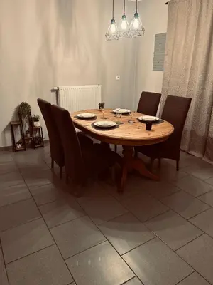 a wooden table and chairs in a living room at Aurelia in Zemst