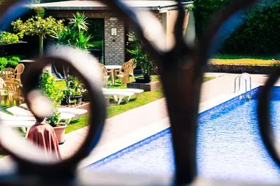 a view of a swimming pool through a pair of scissors at Hotel Pacific in Weelde