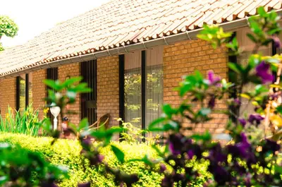 a brick house with windows and flowers in the foreground at Hotel Pacific in Weelde