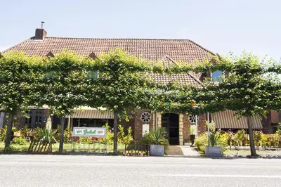 a house with trees and a street in front of it at Hotel Pacific in Weelde