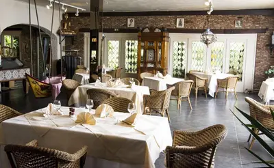 a dining room with white tables and chairs at Hotel Pacific in Weelde