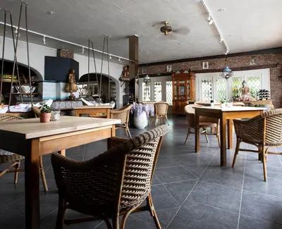 a dining room with tables and chairs in a kitchen at Hotel Pacific in Weelde