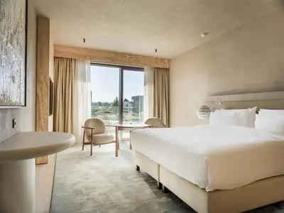 a hotel room with a large bed and a desk at Radisson Collection The National Hotel, Brussels in Zaventem