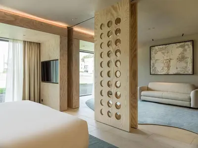 a bedroom with a bed and a living room at Radisson Collection The National Hotel, Brussels in Zaventem