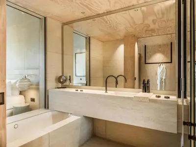 a bathroom with a tub and a sink and a mirror at Radisson Collection The National Hotel, Brussels in Zaventem