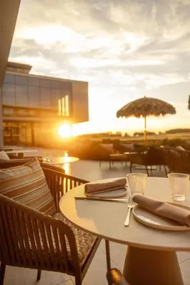 a table with chairs and an umbrella on a patio at Radisson Collection The National Hotel, Brussels in Zaventem