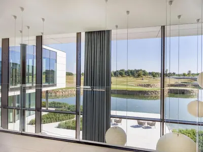 a room with large windows and a view of a lake at Radisson Collection The National Hotel, Brussels in Zaventem