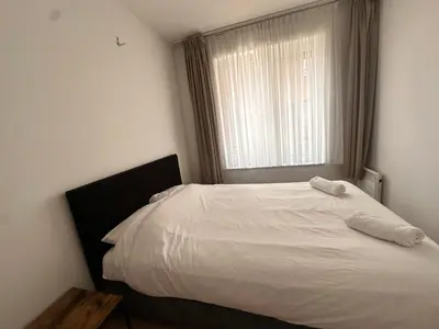 a white bed in a bedroom with a window at Modern 2 Bedroom Apartment for 6 - City Center in Brussels