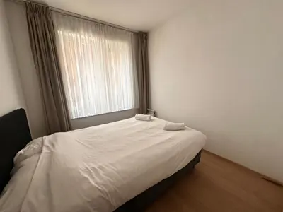 a bed in a room with a large window at Modern 2 Bedroom Apartment for 6 - City Center in Brussels