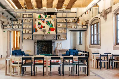 a room with a table and chairs and a fireplace at JAM Ghent in Ghent