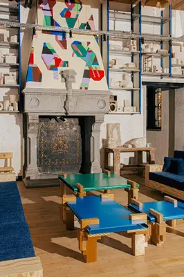 a living room with two tables and a fireplace at JAM Ghent in Ghent