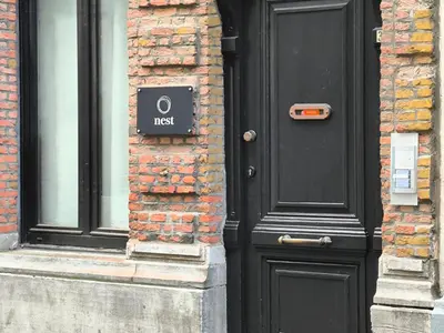 a black door with a first sign on a brick building at Lovely City Centre Duplex in Antwerp