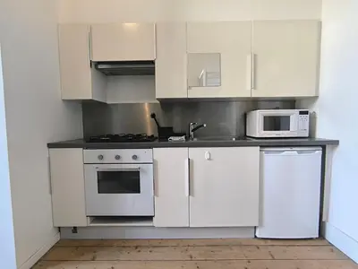 a kitchen with white cabinets and a stove and microwave at Lovely City Centre Duplex in Antwerp