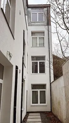 a white apartment building with a walkway in front of it at Modern Stay in Antwerp in Antwerp