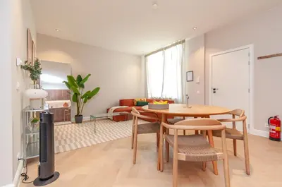a living room with a table and chairs and a tv at Modern Stay in Antwerp in Antwerp