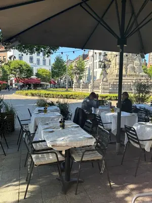 a group of tables and chairs under an umbrella at Modern Stay in Antwerp in Antwerp