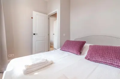a white bed with two towels on top of it at Modern Stay in Antwerp in Antwerp