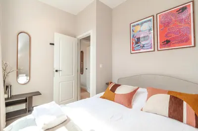 a white bedroom with a bed and a mirror at Stylish Apartment in 't Zuid in Antwerp