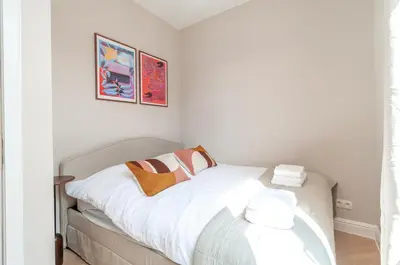 a bedroom with a bed with white sheets at Stylish Apartment in 't Zuid in Antwerp