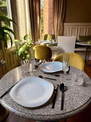 a table with plates and glasses on top of it at Boutique Cogels Osy Suite Four Garden in Antwerp