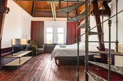 a bedroom with a bed and a spiral staircase at Boutique Cogels Osy Suite Four Garden in Antwerp
