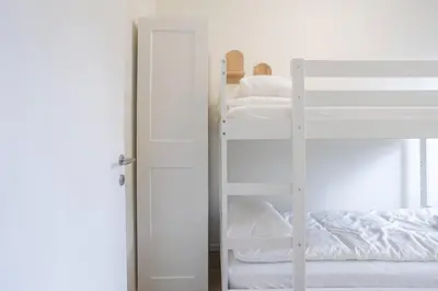 a room with two bunk beds and a door with a ladder at Chic Antwerp Stay 3BR Comfort in Antwerp