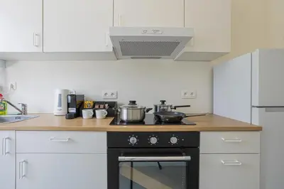 a kitchen with a stove with pots and pans on it at Chic Antwerp Stay 3BR Comfort in Antwerp