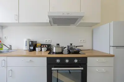 a kitchen with a stove with pots and pans on it at Chic Antwerp Stay 3BR Comfort in Antwerp