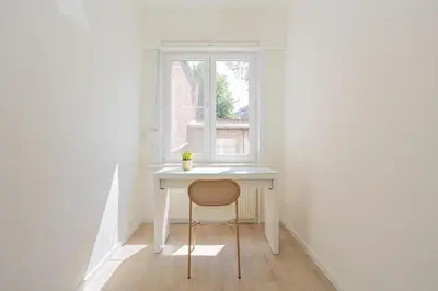 a white desk with a chair in front of a window at Chic Antwerp Stay 3BR Comfort in Antwerp