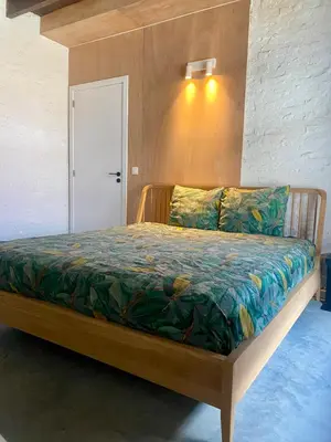 a bedroom with a wooden bed in a room at Hoeve DeKleinheide - De Hoeve in Dessel