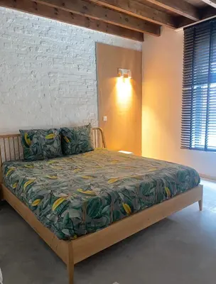 a bedroom with a bed with a colorful bedspread at Hoeve DeKleinheide - De Hoeve in Dessel