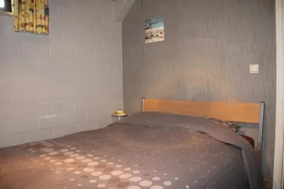 a bedroom with a bed with a brown blanket on it at Hof Ter Hagen in Lokeren