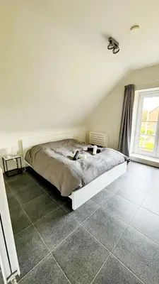 a bedroom with a bed and a large window at Bruggeske aan't bos in Mol