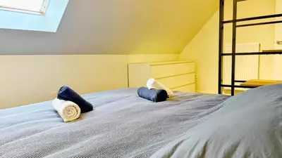a bedroom with a bed with blue pillows on it at Bruggeske aan't bos in Mol