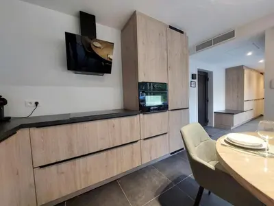 a kitchen with a tv on the wall and a table at Vakantiewoning in 't groen-Lille in Lille